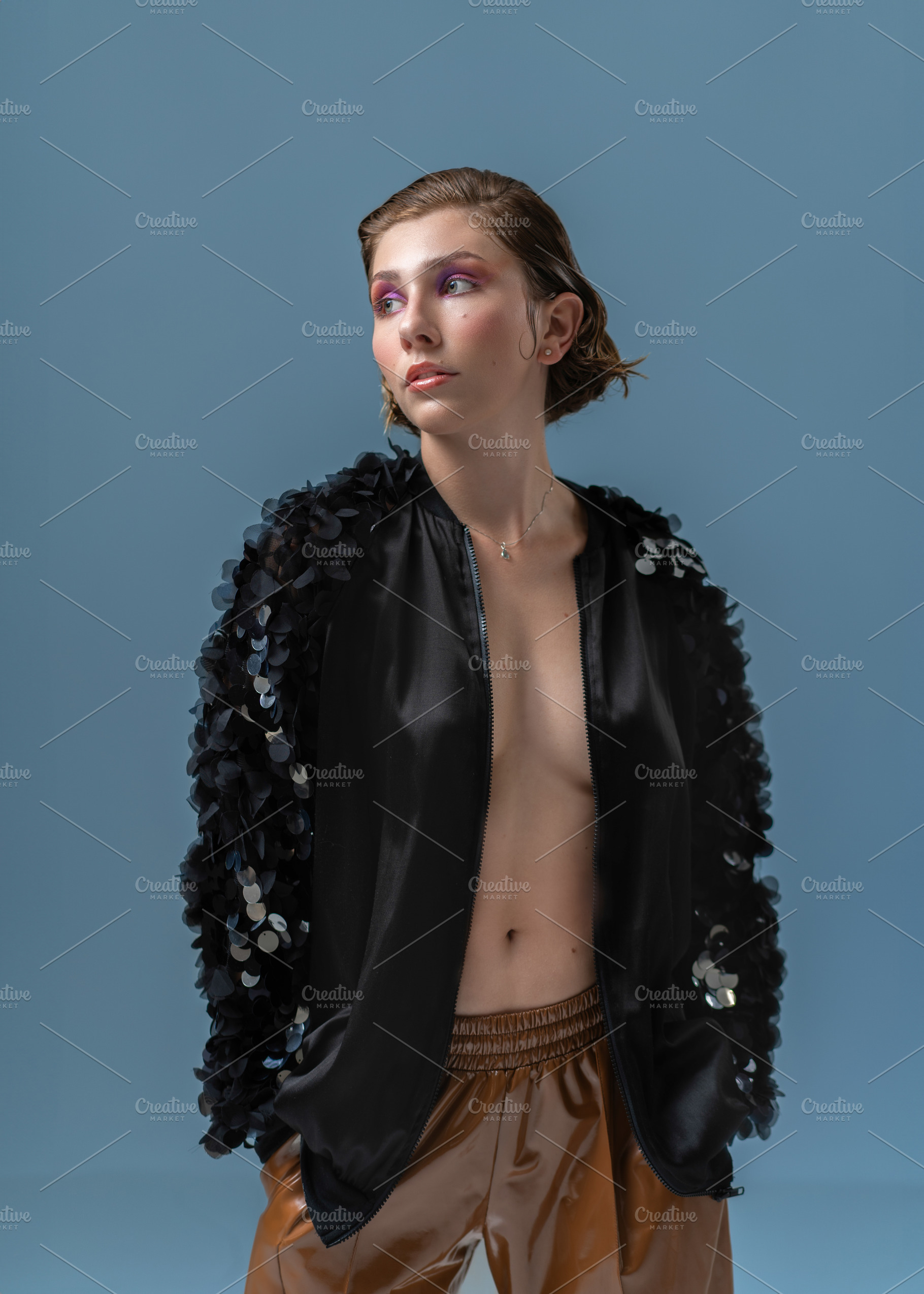Sensuous female model with hands in pockets wearing black jacket, a Person Photo by andreonegin market