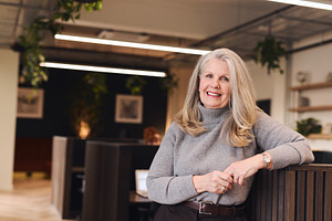 Portrait of confident senior white woman with long grey hair smiling and lookin
