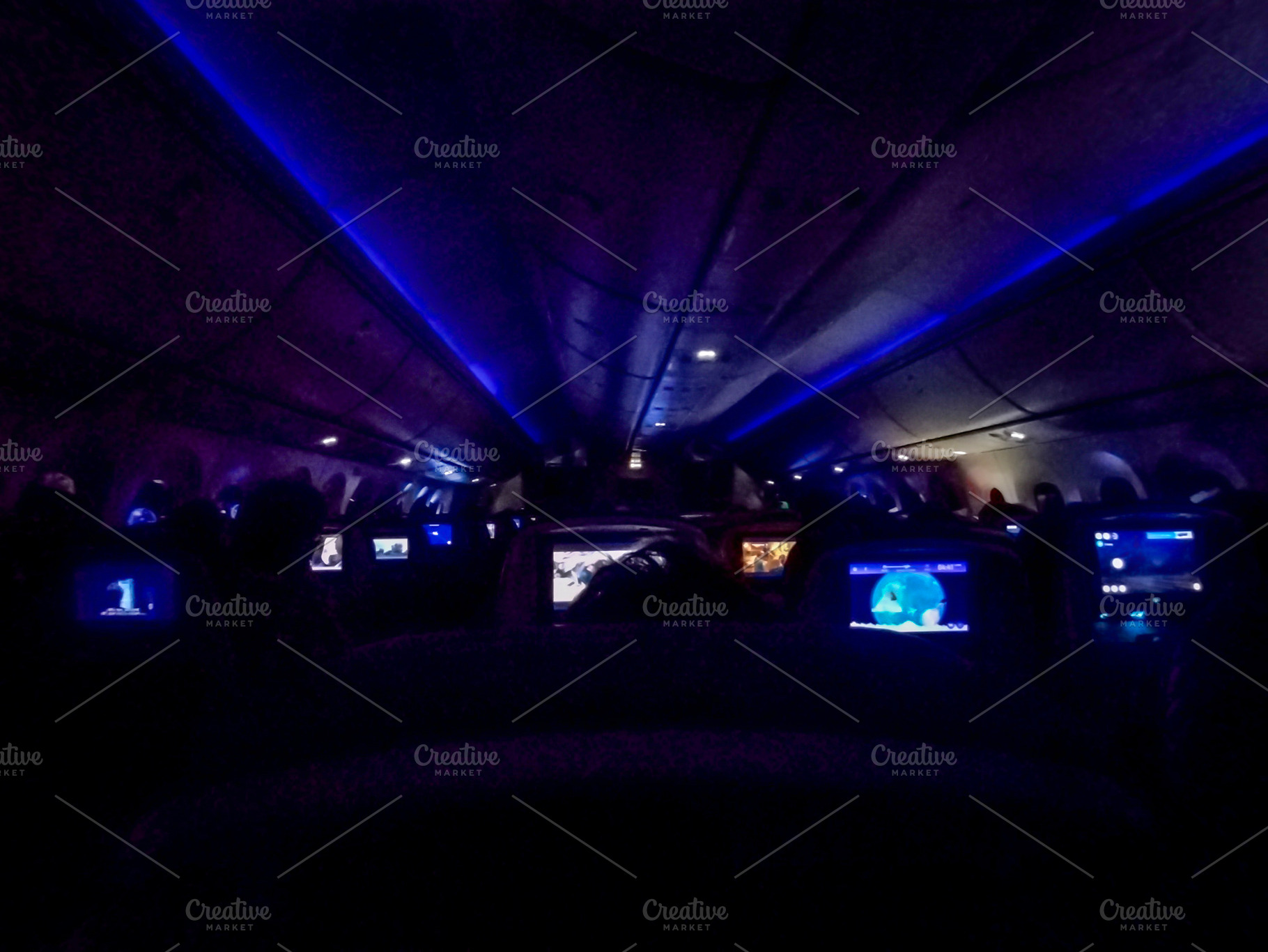 Interior of airplane cabin with personal screens on seats, a Transportation Photo by DanFLCreativo