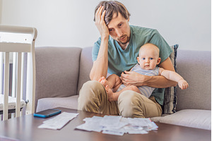 Father sitting on sofa holding baby