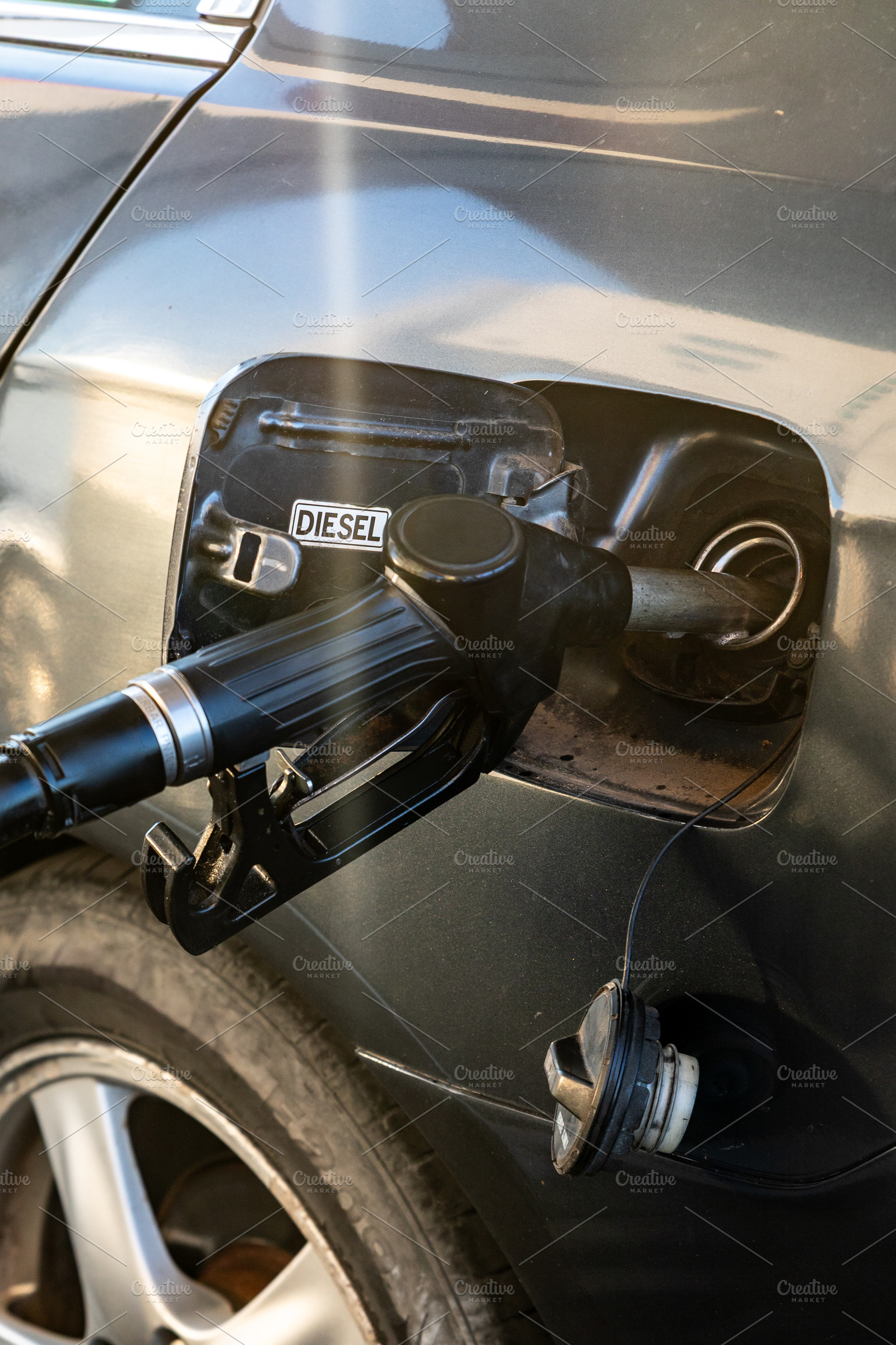 Close-up view of a diesel car being refueled at a gas station, showing fuel noz, a Transportation Photo by Ales Munt