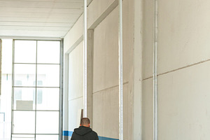Construction worker installing aluminum pillars for plasterboard wall in indust, an Industrial Photo by Antonio Gravante Market
