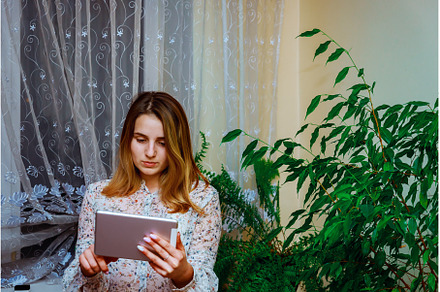 Young girl holding and using tablet, a Person Photo by Ungvar Studio