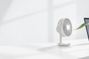 Cooling desk fan and laptop on white, a Photo by Dvoevnore photos