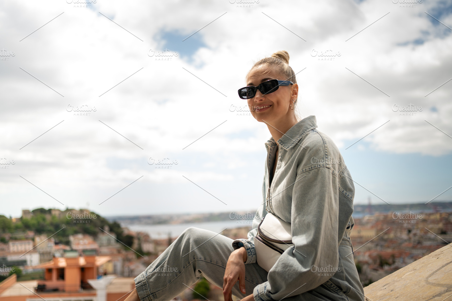 Happy woman sitting on retaining wall at Senhora do Monte viewpoint, a Person Photo by andreonegin market
