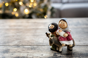 Nativity figurines of Holy Family with Christmas tree lights in background, a Food & Drink Photo by etorres69