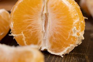 peeled orange ripe tangerines on the table, a Photo by rsoollAI