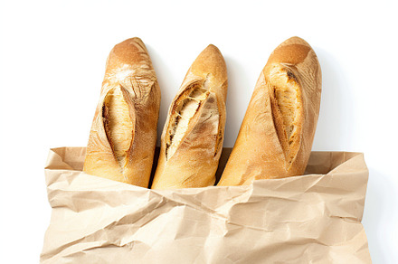 Freshly baked baguette in paper bag isolated on white background, a Food & Drink Photo by AlyaAnd