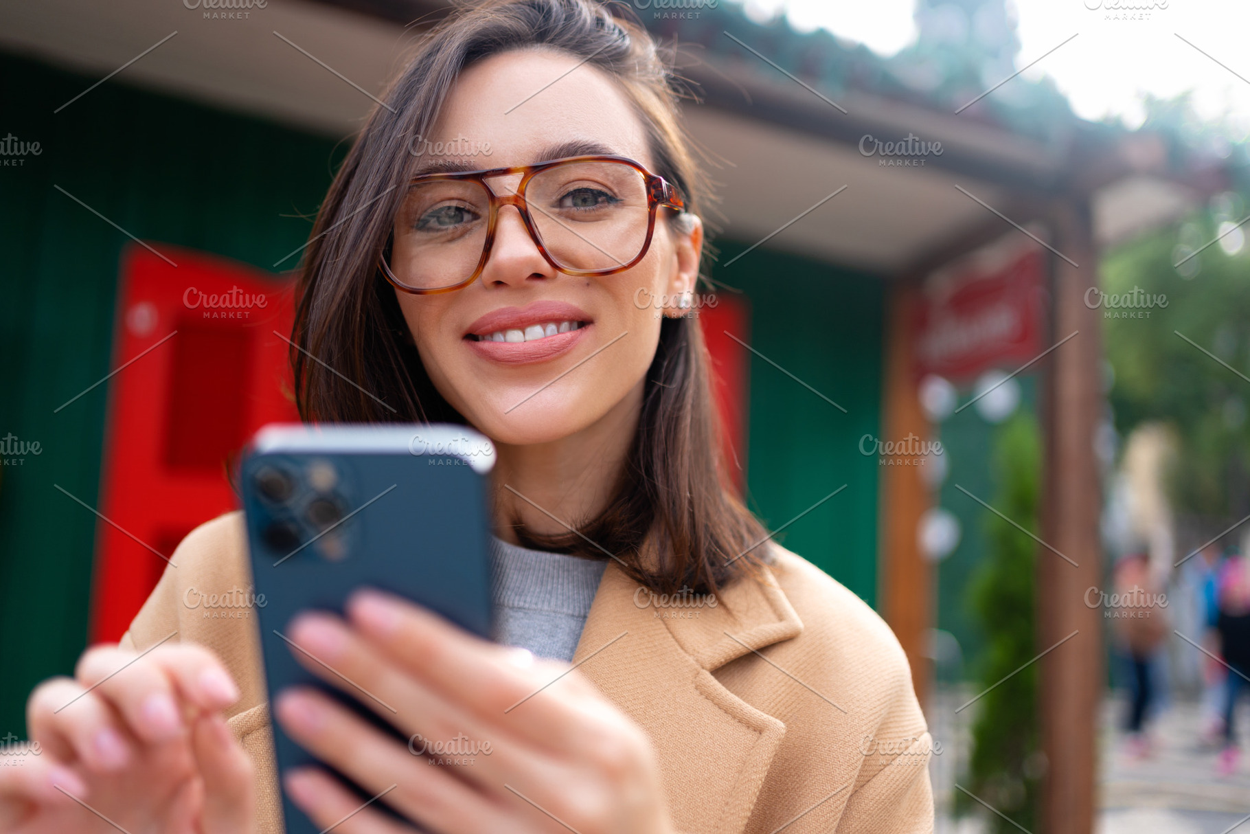 Woman in glasses using mobile phone at day in the city, a Person Photo by andreonegin market