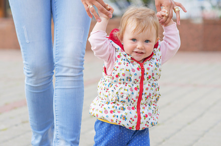 A baby boy walks with mom featuring mother, parent, and happy