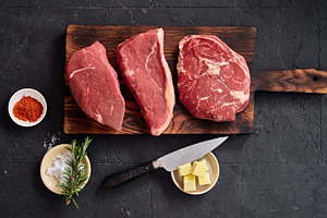 Raw rib-eye, roast beef, flank, and rump steak displayed on a wooden cutting bo, a Food & Drink Photo by Asya Nurullina