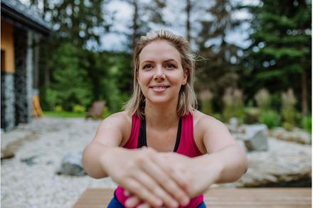 Young woman exercising, stretching, a Person Photo by HalfPoint