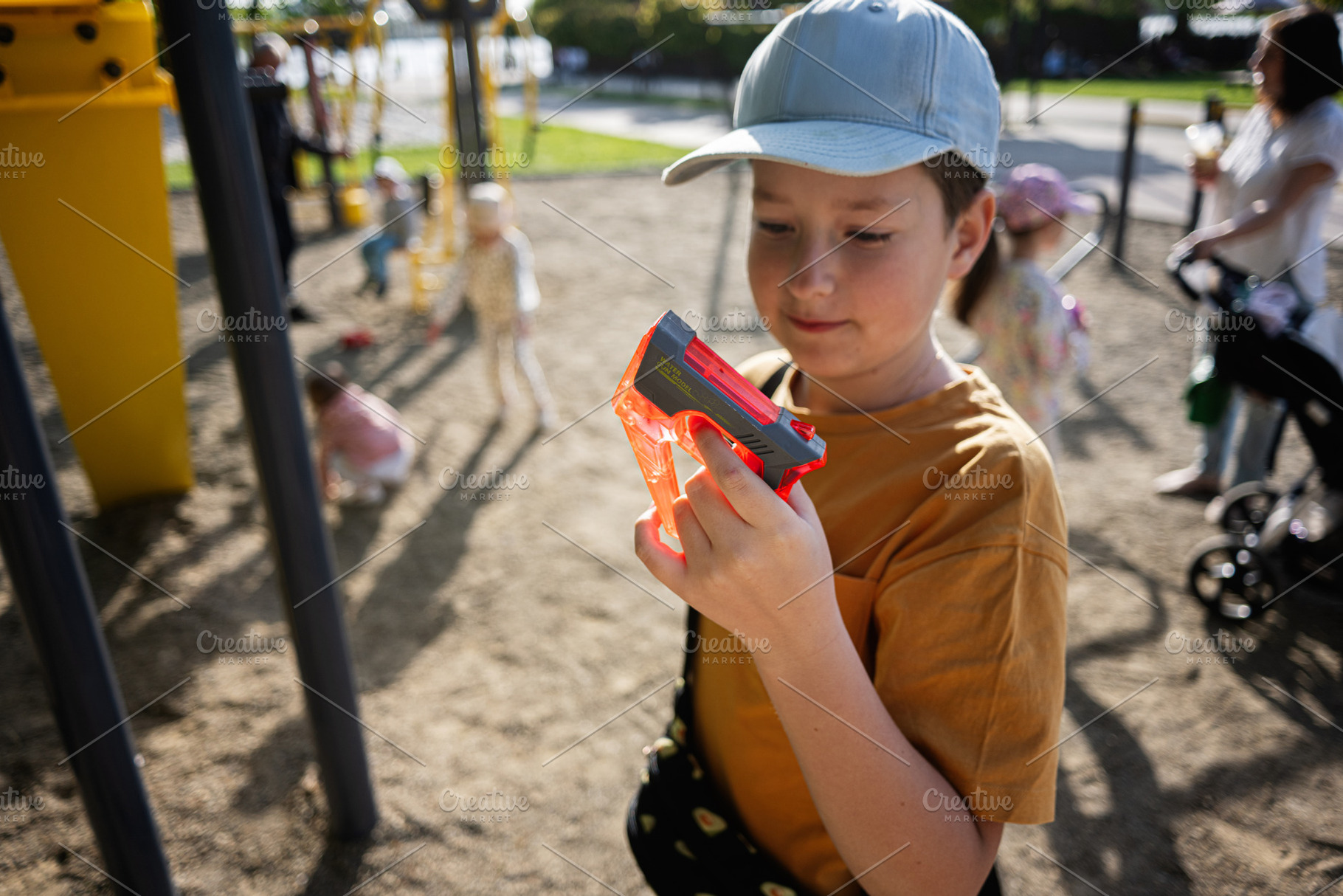 Young boy holding a toy while playing at an outdoor park playground, a Person Photo by AS photostudio