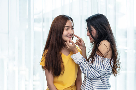 Two Asian women touching chin and playing with together. People, a Person Photo by Ministocker