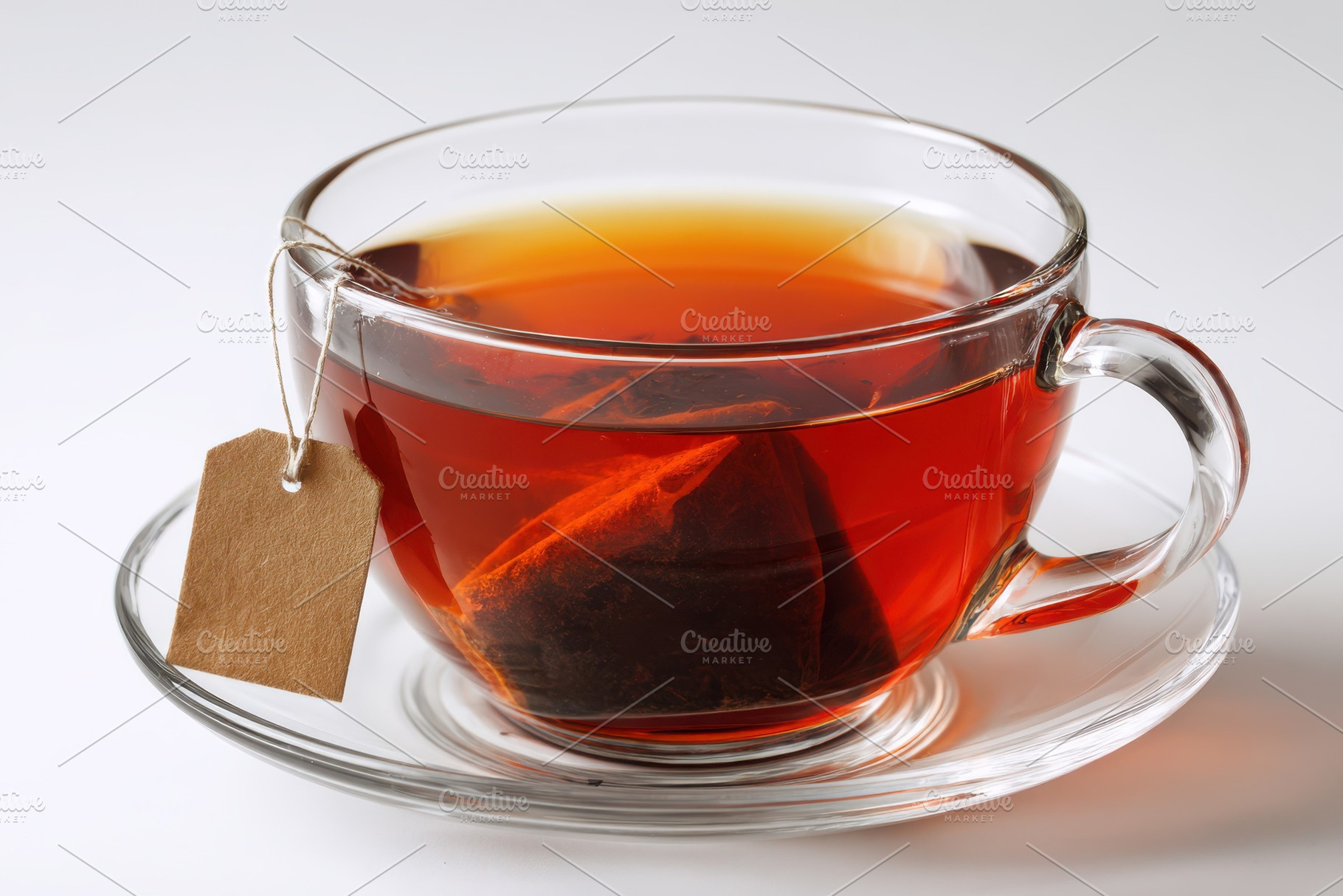 A glass cup of tea with a tea bag an, a Photo by Pixeness Studio