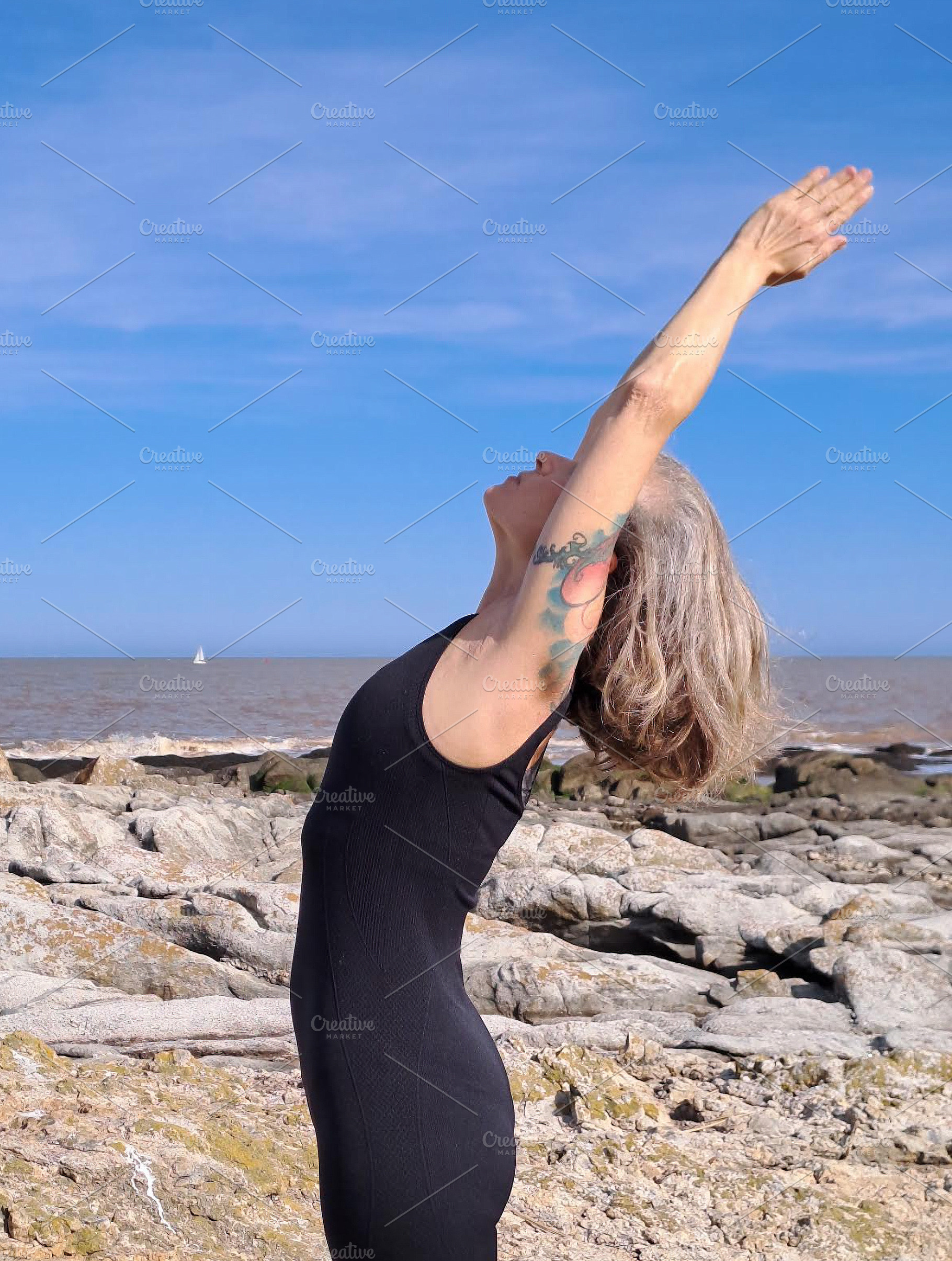 Woman practices yoga on a rugged rocky surface, a Person Photo by DanFLCreativo