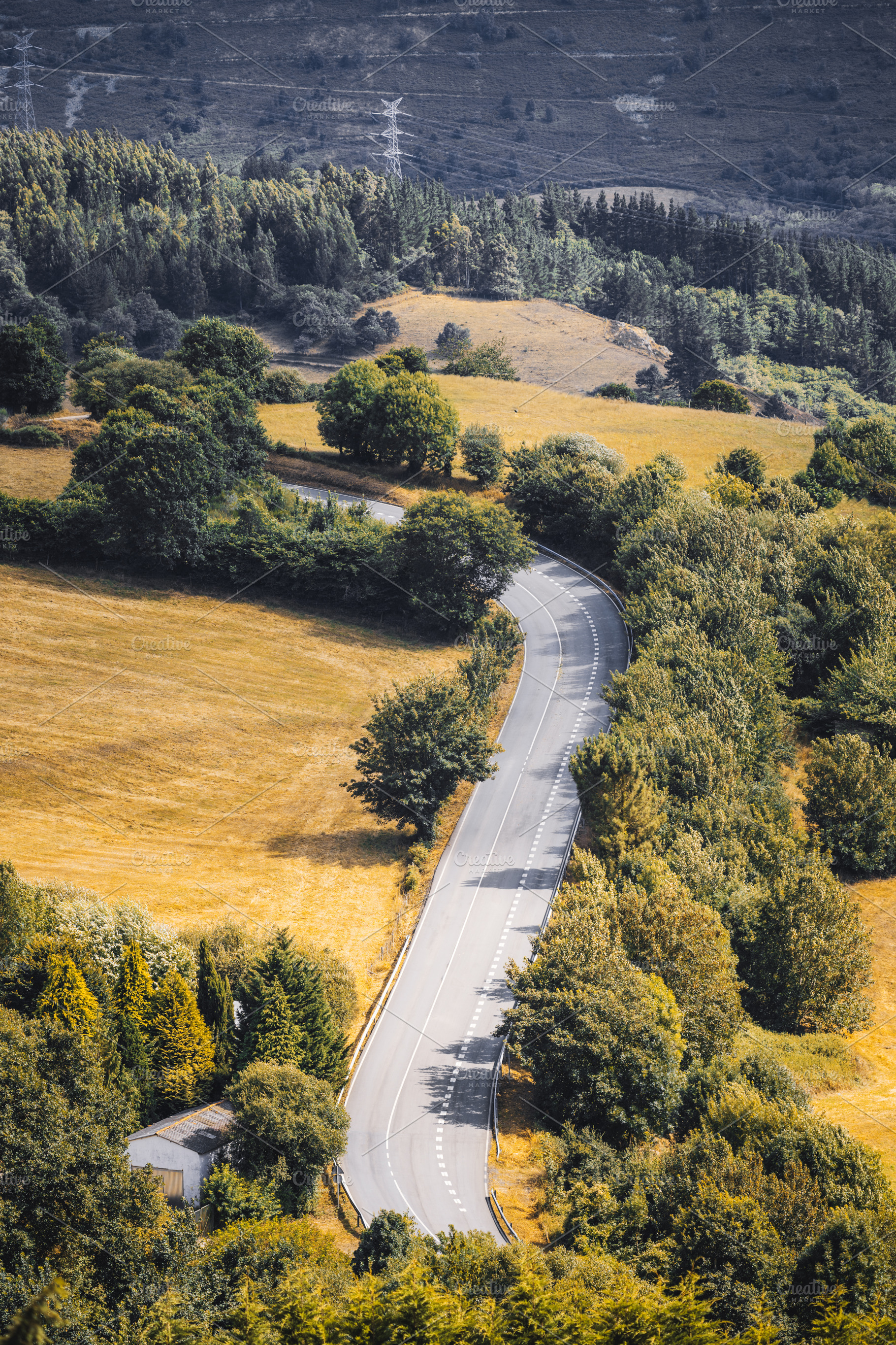 Curved rural road in valley, a Transportation Photo by SkyNext