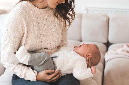 Mother holding crying baby, a Person Photo by morrowlight