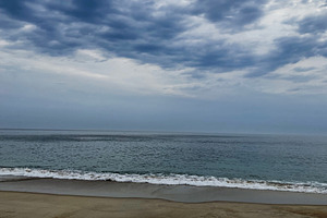 Sunlit clouded sky over peaceful beach during quiet morning, a Photo by AS photostudio