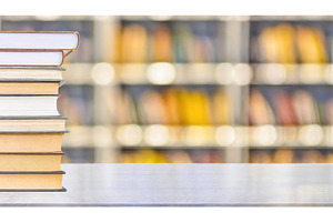 Stack of books with blurred library, a School & Education Photo by Igor Tichonow