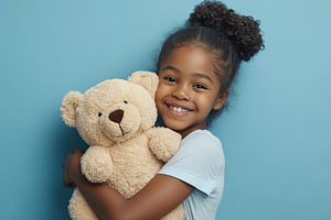 Old African girl embracing a plush teddy bear while smiling joyfully in a blue, a Person Photo by AlyaAnd