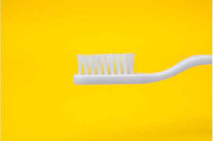 White toothbrush on yellow, a Health & Medical Photo by olhovyi_photographer