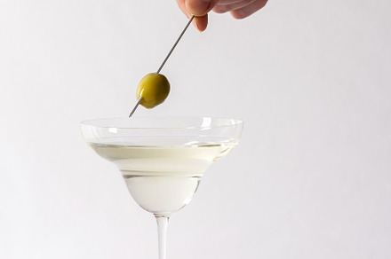 Man puts an olive in a glass, a Food & Drink Photo by Pandateam
