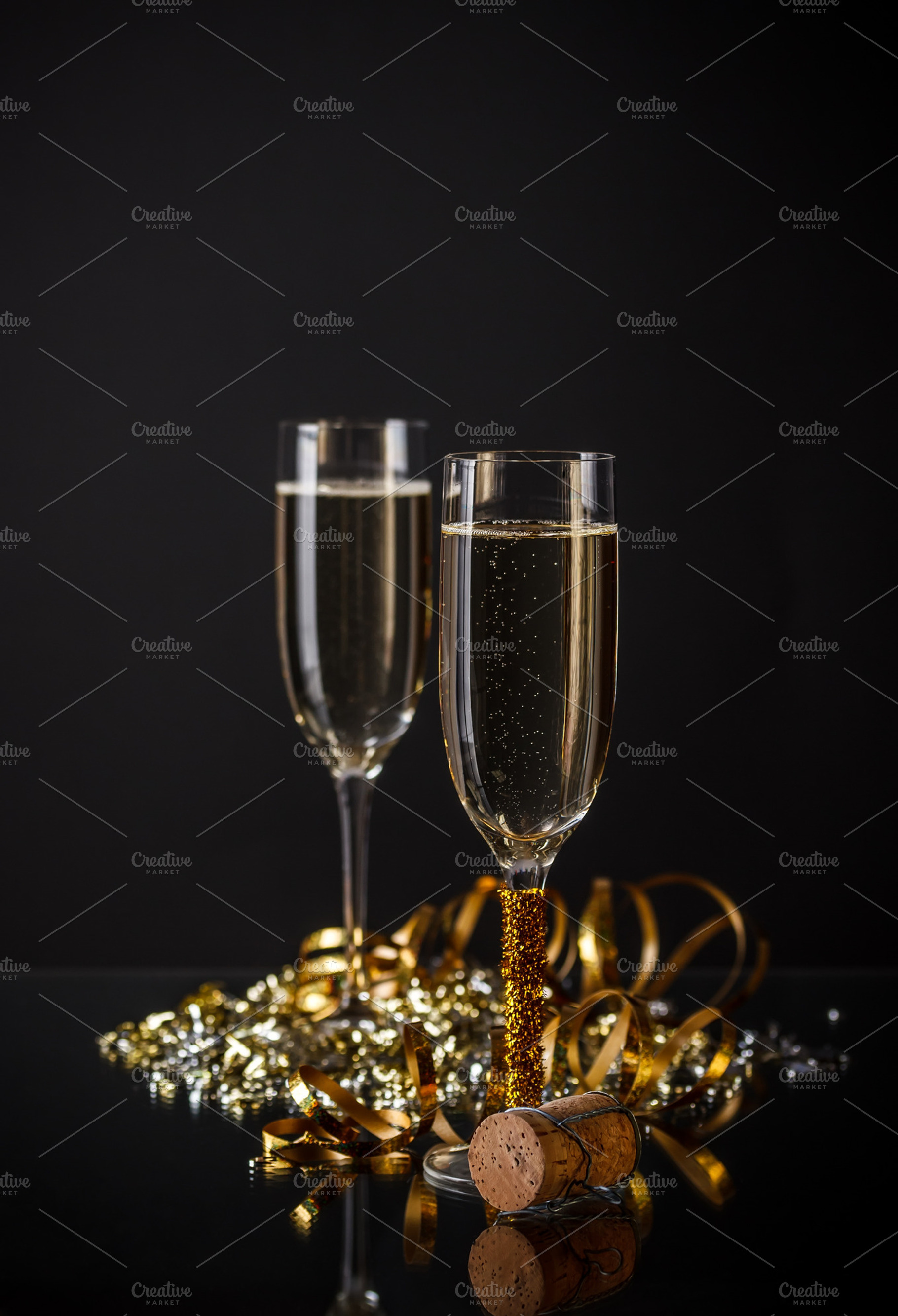 Two glasses of champagne containing black background, holiday, and alcohol