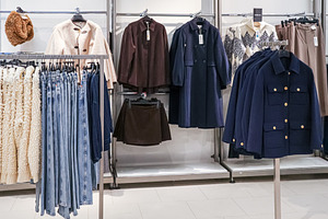 Retail store offering new season fashion apparel on hangers including coats, je, a Photo by Studio ANNA