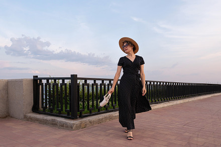 Stylish woman walks on promenade