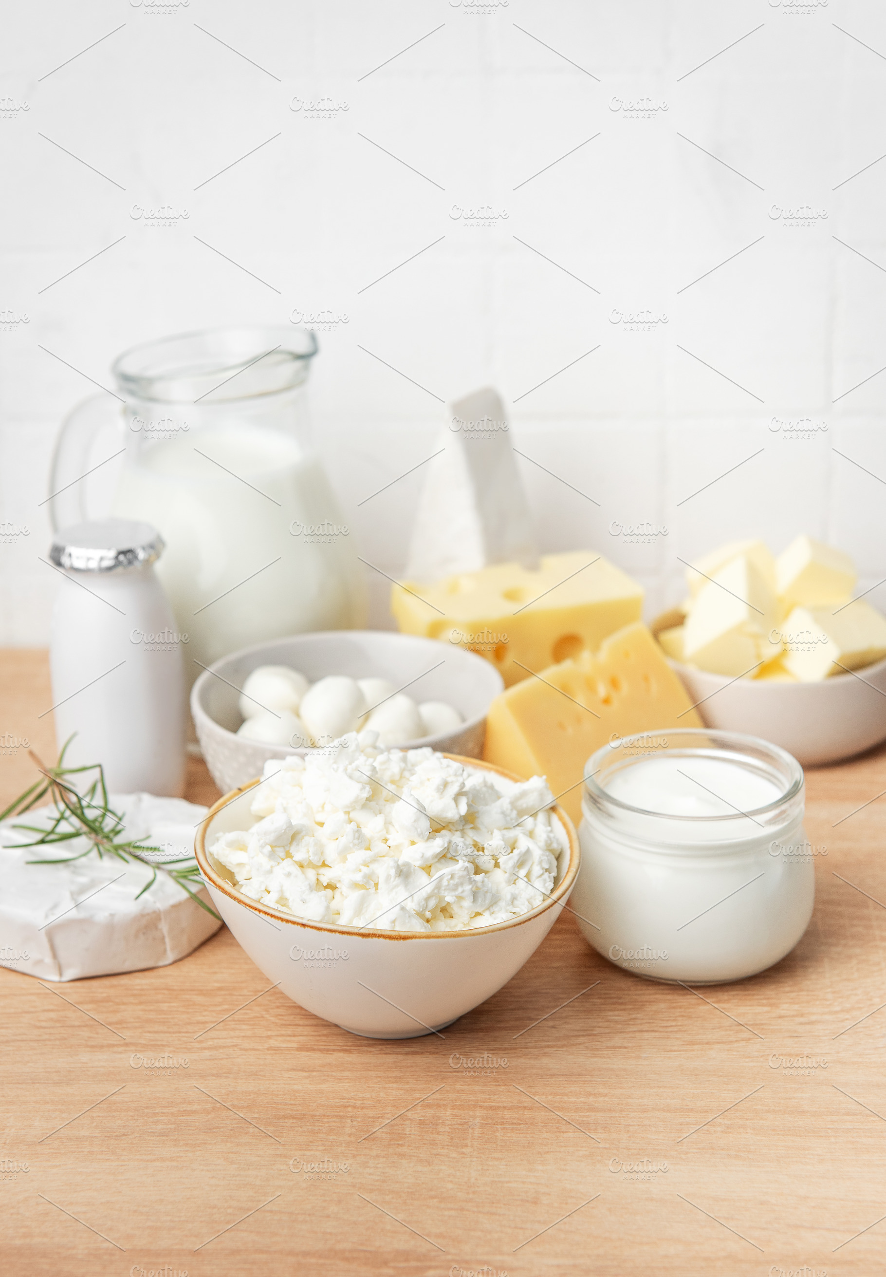 Assortment of fresh dairy products on wooden table, a Food & Drink Photo by Olena Rudo