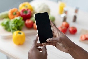Hands of young african american woman hold smartphone with blank screen making, a Person Photo by Prostock-Studio