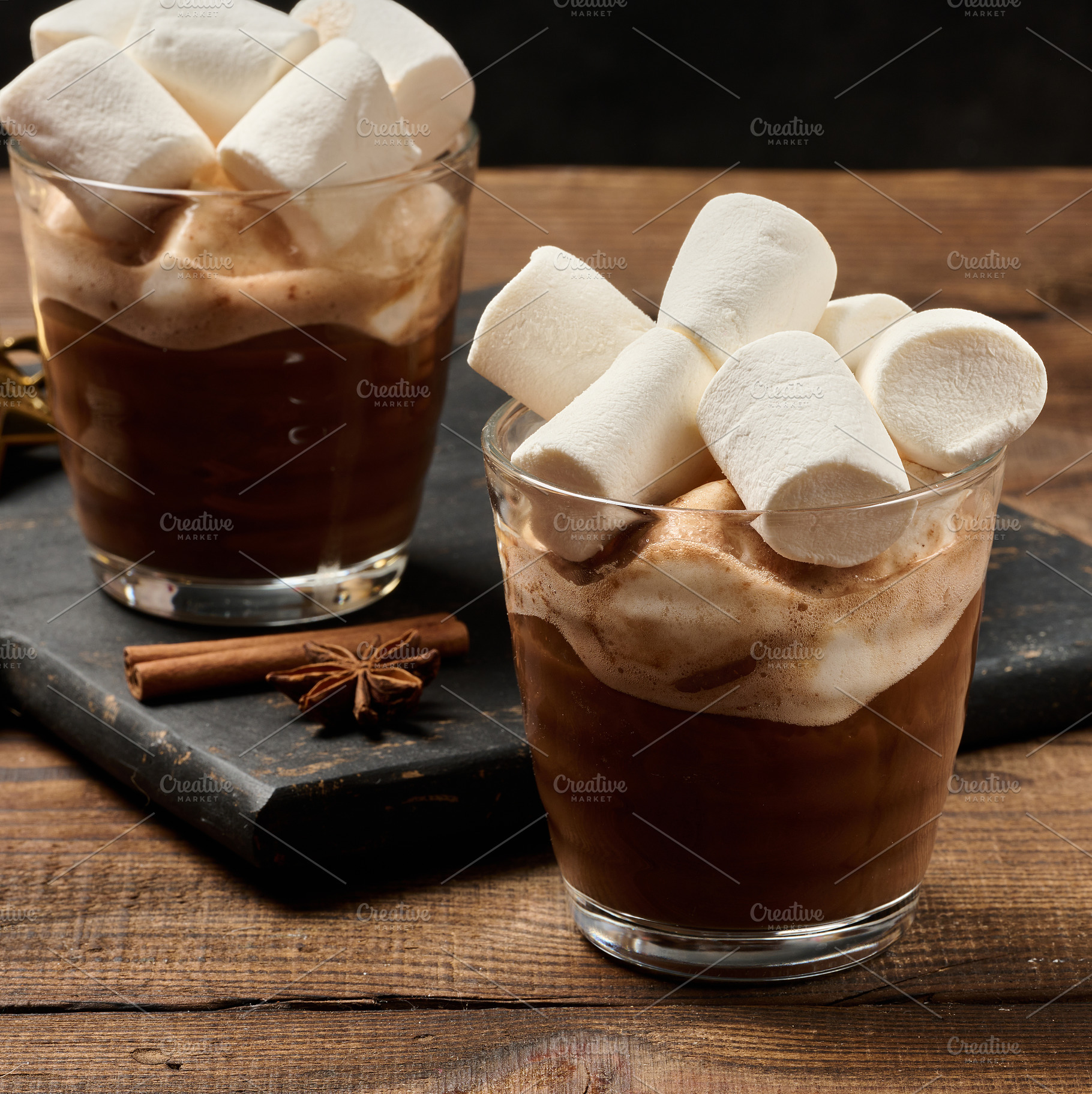 Glasses of hot chocolate with fluffy marshmallows on a wooden ta, a Food & Drink Photo by ndanko