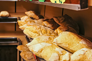 Freshly baked loaves of bread displayed on shelves in a bakery shop, an Abstract Photo by Antonio Gravante Market