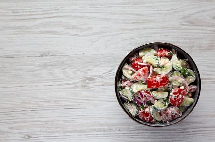 Homemade Tomato Cucumber Feta Salad in a Bowl, top view. Flat la, a Food & Drink Photo by LiudmylaChuhunova