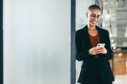 Successful businesswoman reading a text message in an office, a Person Photo by Jacob Lund