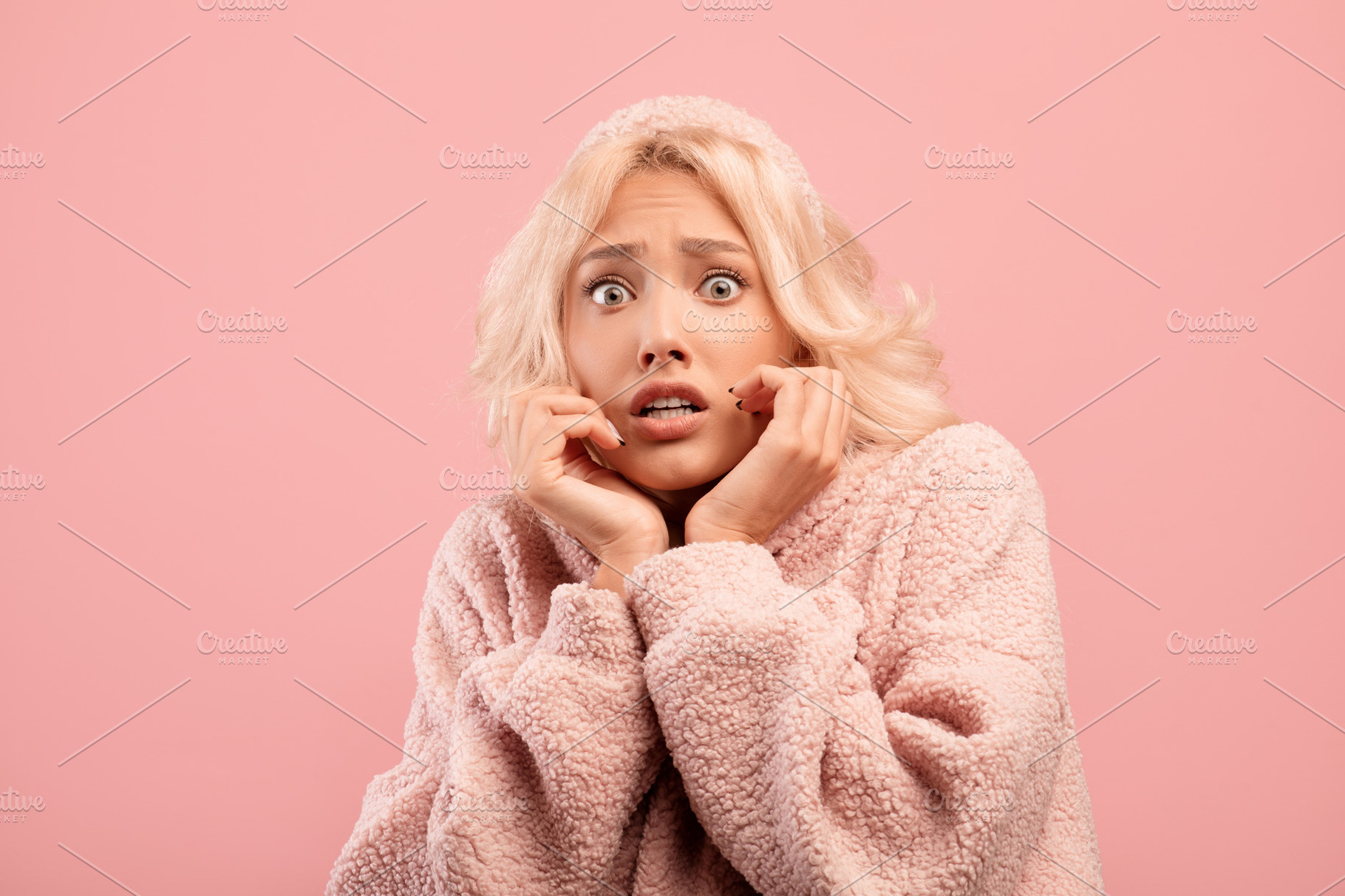 Young caucasian woman feeling scared, touching cheeks with hands, posing on pin, a Photo by Prostock-Studio