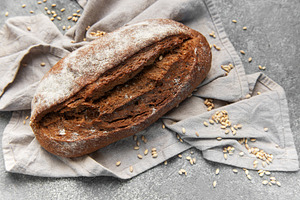 Rustic rye sourdough bread loaf on gray cloth, a Food & Drink Photo by Olena Rudo