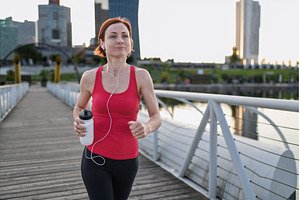 sporty woman running across a city, a Person Photo by HalfPoint