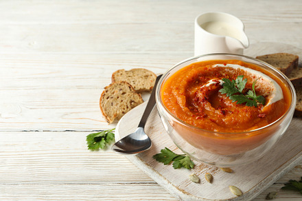 Composition with bowl of pumpkin soup on white wooden background, a Food & Drink Photo by AtlasStudio PRO