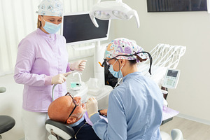Dentist performing dental checkup on senior man assisted by nurse, a Health & Medical Photo by Antonio Gravante Market