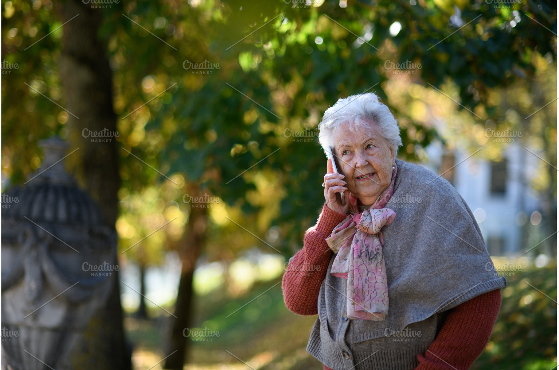 Elderly woman in the park, holding a, a Technology Photo by HalfPoint