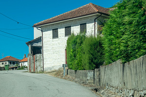Narrow street between stone and whitewashed houses, a Transportation Photo by DanFLCreativo