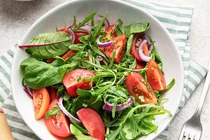 Fresh green salad with tomatoes and arugula, a Photo by Olena Rudo