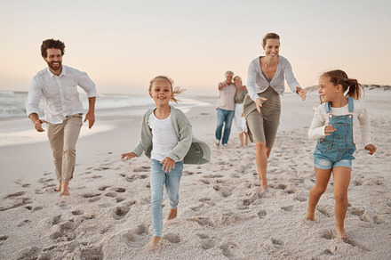 Carefree family bonding on the beach. Excited children playing with their parents on the beach. Grandparents strolling on the beach with grandchildren. Happy children running on the beach with parents, a Photo by Peopleimages.com
