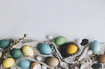 Stylish rustic Easter flat lay. Natural colorful eggs, cherry bl, a Holiday Photo by Sonjachni