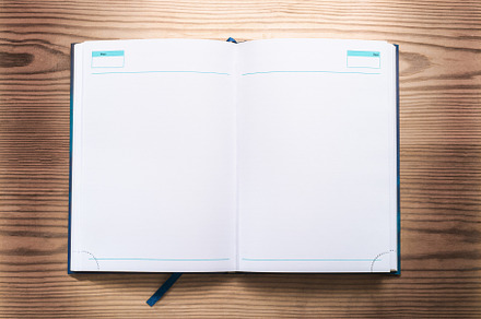 Notepad opened on wooden background top view flat lay, a Background Photo by oleghz