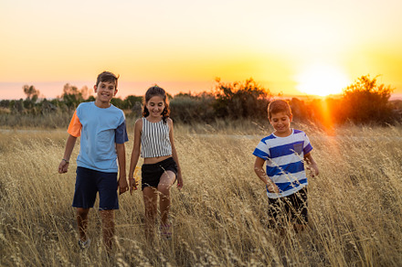 Three little friends in a field in their summer vacation at suns