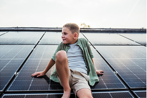 Boy sitting on roof with solar, a Technology Photo by HalfPoint
