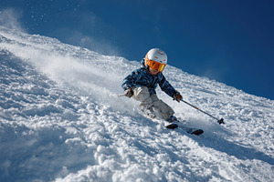 Child skiing down snowy mountain slo, a Photo by Pixeness Studio